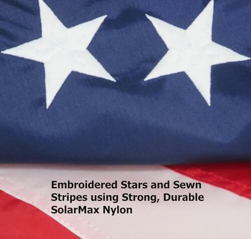 Close-up of American flag with embroidered stars and sewn stripes.